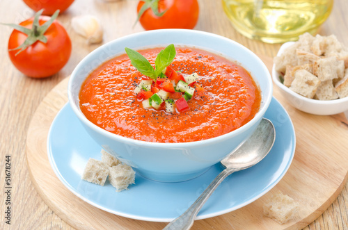 фотографія cold tomato soup gazpacho with basil, croutons in a bowl