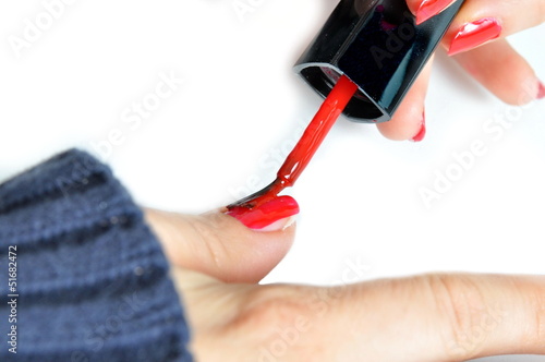 Young girl painting her nails red