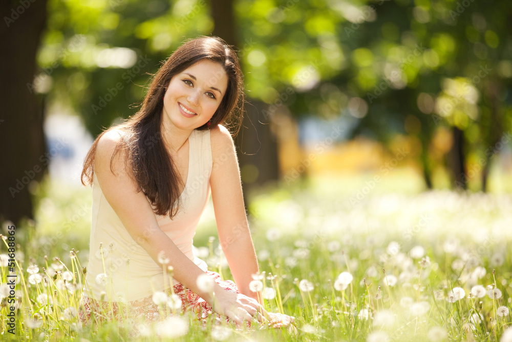 Cute woman rest in the park with dandelions Cute woman rest in the park with dandelions