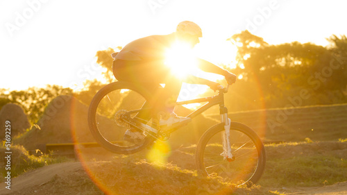 Ciclista en bump a contraluz, atardecer, deporte, bicicleta.