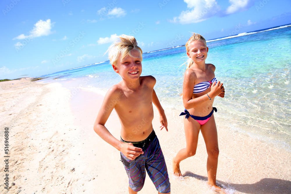 Kids running on a sandy beach in Caribe