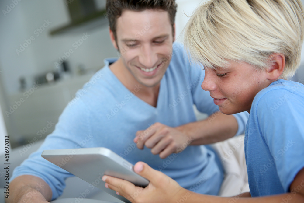 Father and son using digital tablet at home Father and son using digital tablet at home