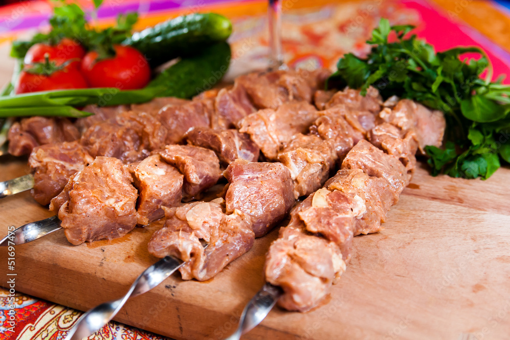 Raw kebab on wooden board