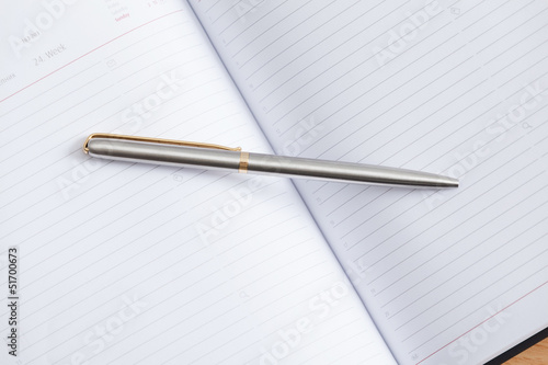 Close up view of pen lying on the open notebook