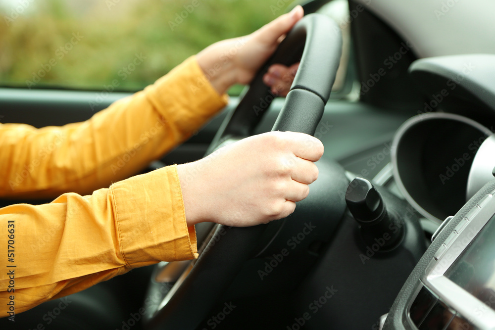 Female hands over a wheel in the car, close up