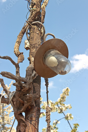 Old lamp on wooden post over blue sky