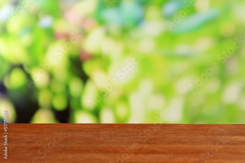 Wooden table on bright green background
