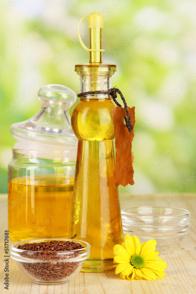 Useful linseed oil on wooden table on natural background Useful linseed oil on wooden table on natural background