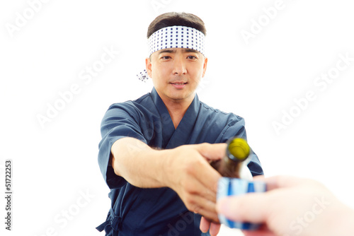 日本酒の瓶を持つ笑顔の寿司職人