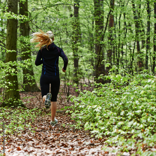 Young female running into the forest