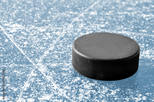 Photography black hockey puck on ice rink