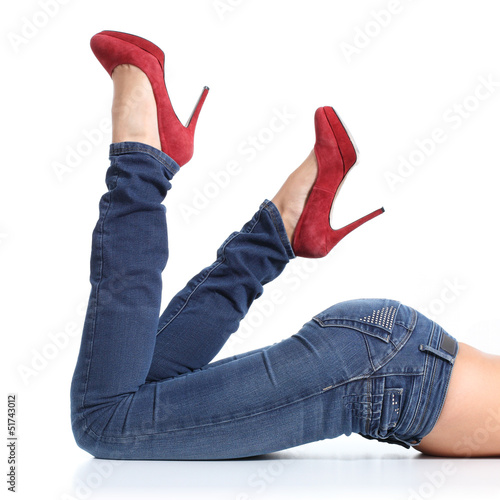 Close up of a beautiful woman legs with blue jeans and red heels photo