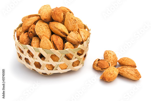 almond nuts in weaven basket on white photo