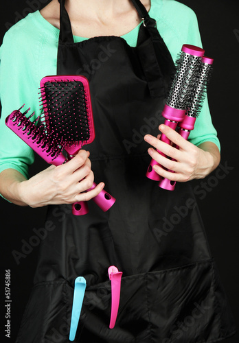 Hairdresser in uniform with working tools  isolated on black