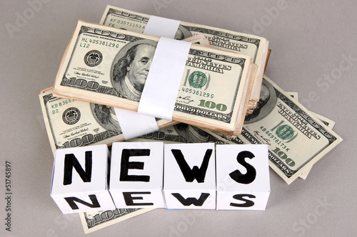 White paper cubes labeled "News" with money on grey background
