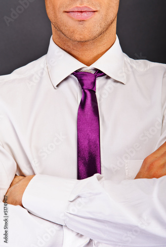Man with purple tie over dark background