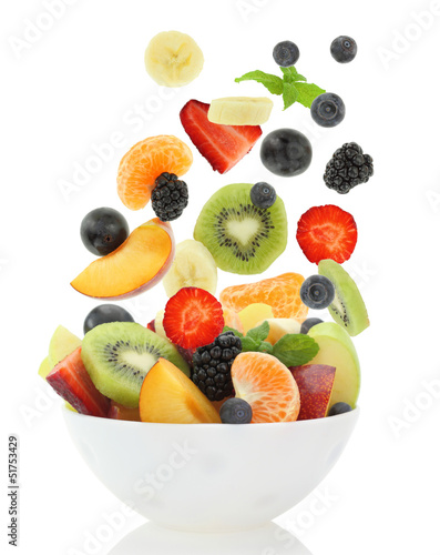 Fresh mixed fruit salad falling into a bowl of salad