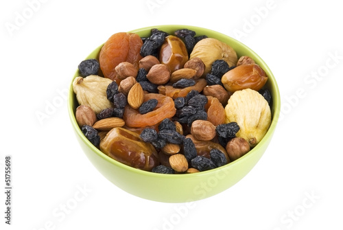 Dried fruits and nuts mixed in green bowl isolated on white