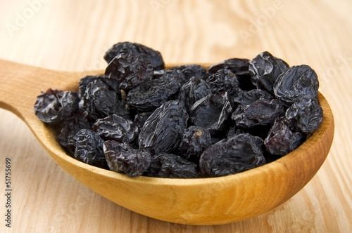 Blue raisins in wooden spoon close up