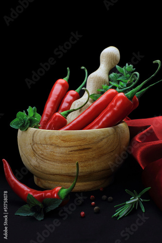 Red hot chili peppers with herbs in wooden