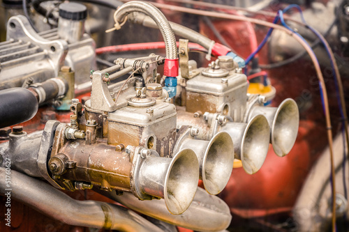 vintage muscle car carburetor and engine bay closeup photo