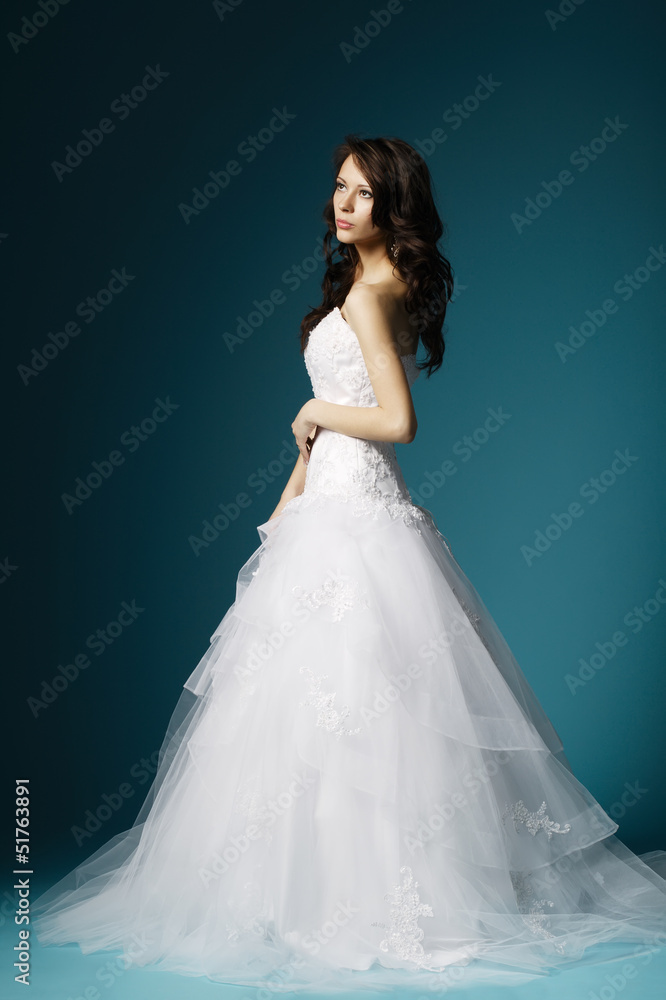 beautiful girl in wedding dress on blue background