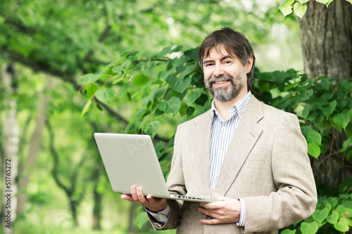 Portrait of happy middle-aged businessman holding notebook and s