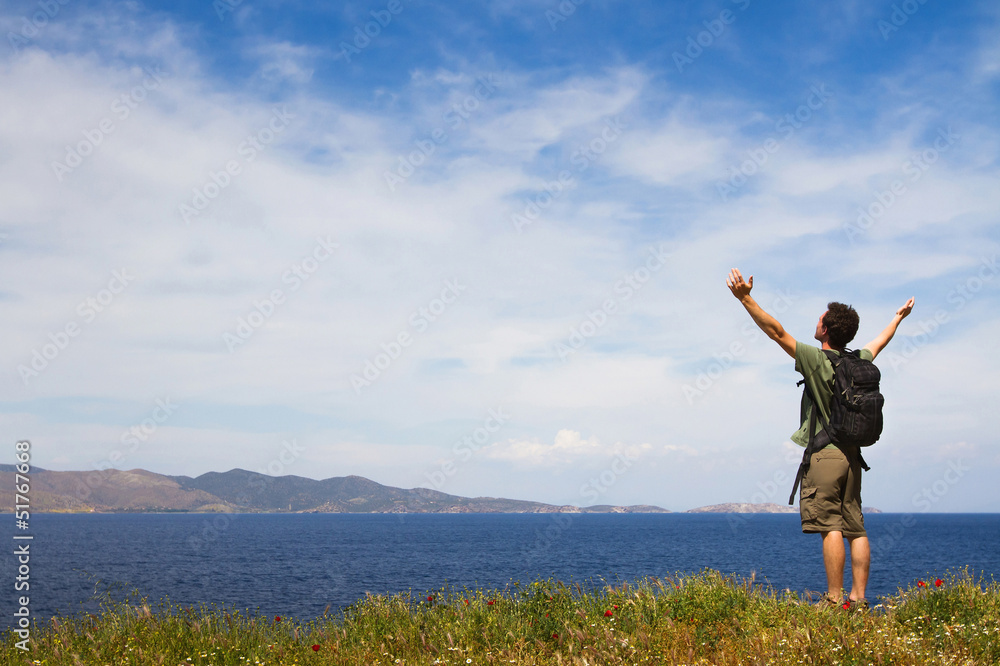 Young tourist with backpack enjoying sea view from top of a hill Young tourist with backpack enjoying sea view from top of a hill
