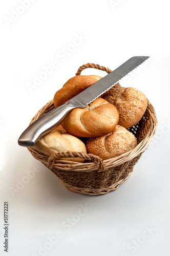 Bread loaves in a wicker basket with knife on top