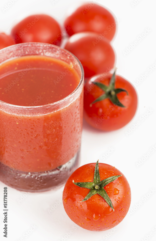 Glass of tomato juice and tomatoes on a white background Glass of tomato juice and tomatoes on a white background