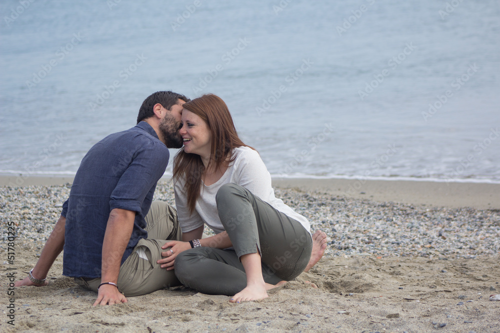 Couple of young and beautiful friends, flirting in a seaside