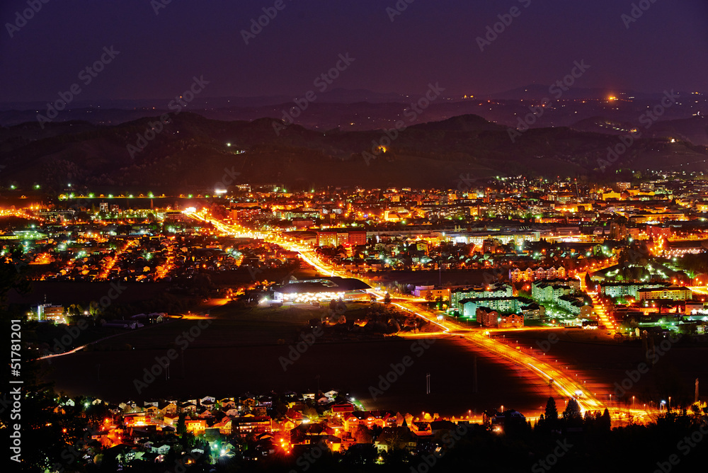 Maribor by night with hills in background by the full moon