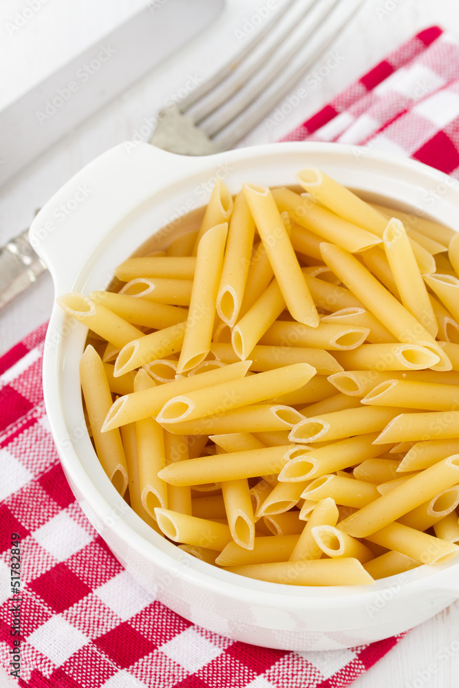 dry penne in white bowl dry penne in white bowl