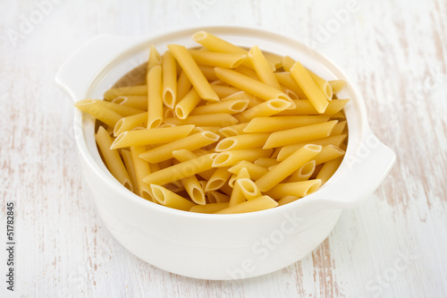 uncooked pasta in white bowl