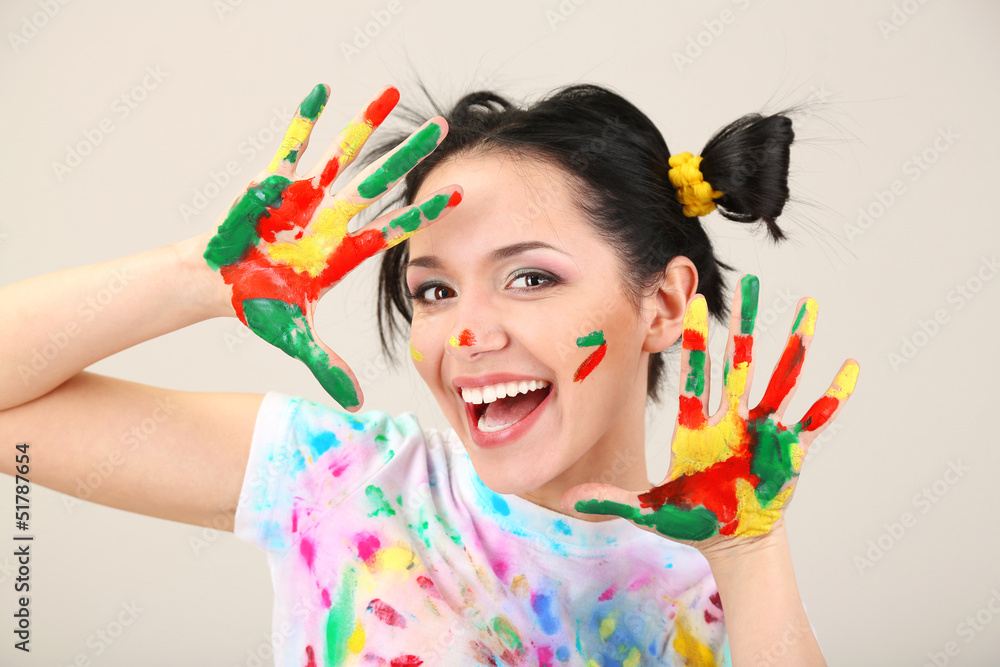 Young pretty painter with hands in paint, on gray background Young pretty painter with hands in paint, on gray background
