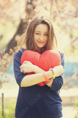Romantic girl with heart near tree