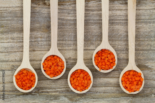 Red lentils on wooden spoons