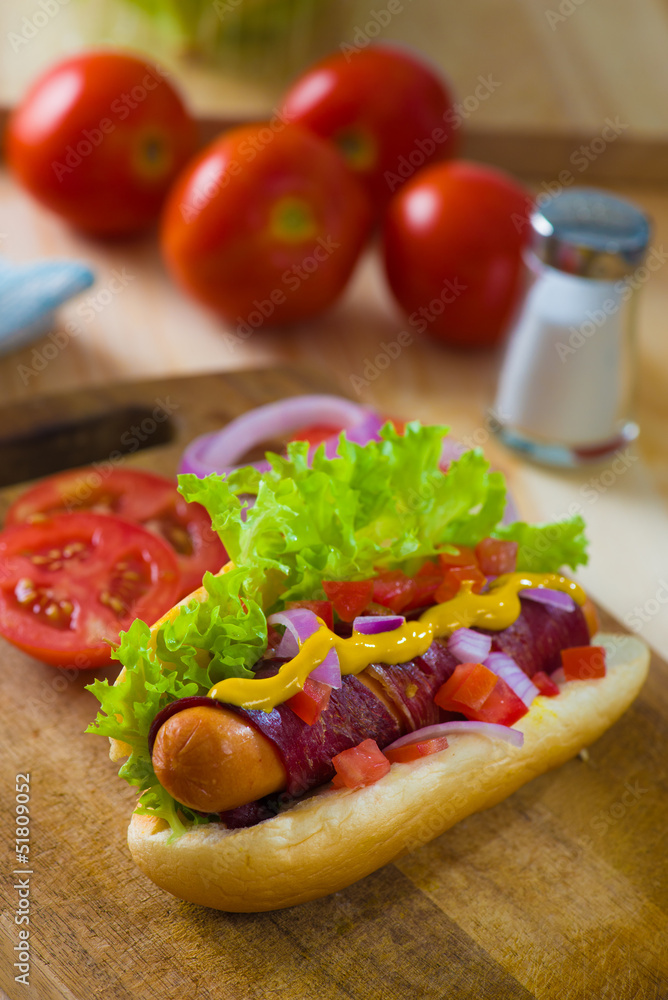 hot dog fast food with plenty of raw ingredients on the backgrou hot dog fast food with plenty of raw ingredients on the backgrou