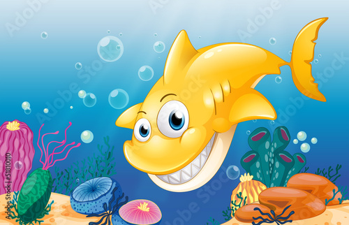 A yellow shark smiling under the sea