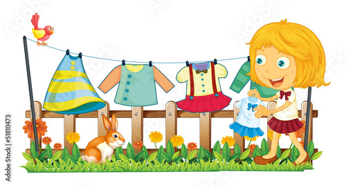 A girl hanging her clothes at the garden