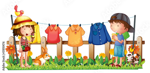A girl and a boy in the garden with the hanging clothes