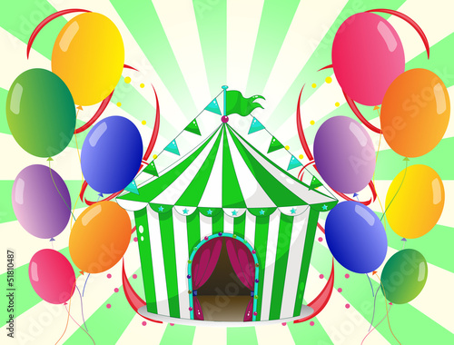 A green circus tent at the center of the colorful balloons