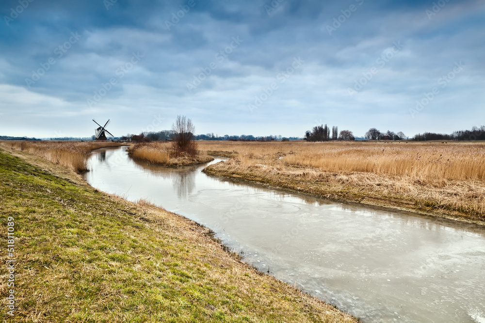 frozen river and dutch windmill