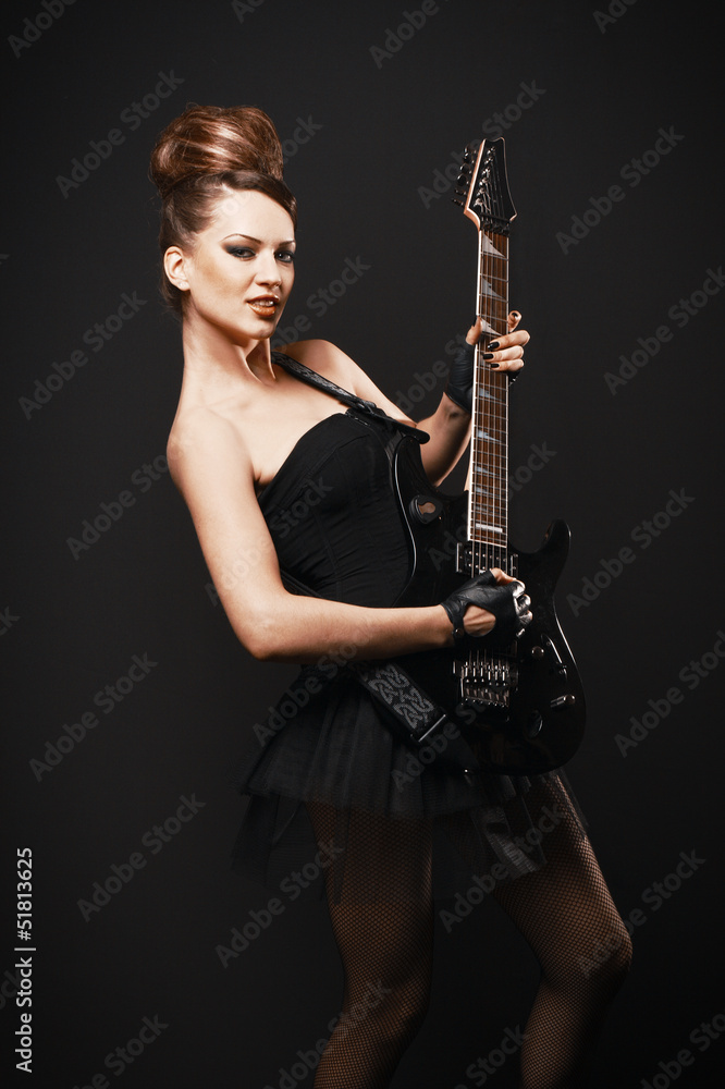 Rock female with guitar over dark background.