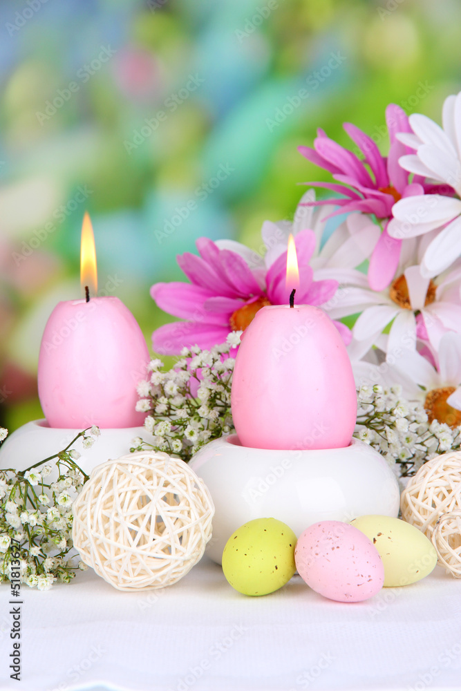 Easter candles with flowers on bright background Easter candles with flowers on bright background