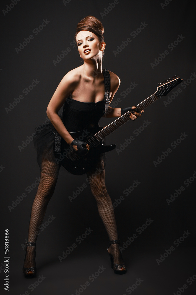 Rock female with guitar over dark background.