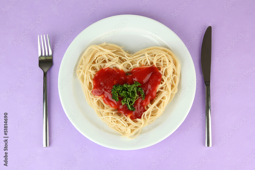 Cooked spaghetti carefully arranged in heart shape and topped Cooked spaghetti carefully arranged in heart shape and topped