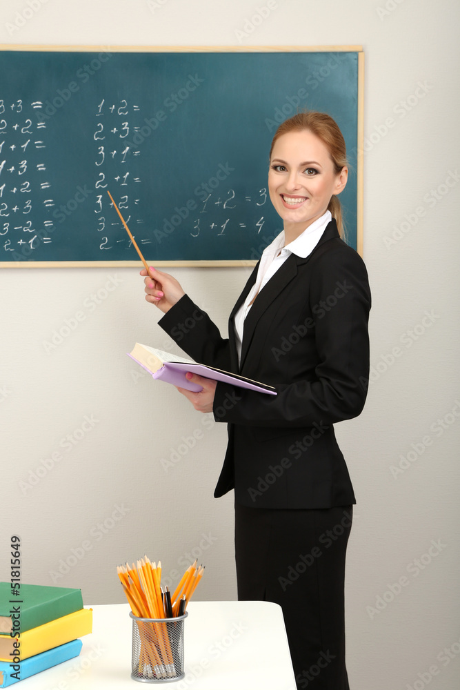 Portrait of teacher woman near chalkboard in classroom Portrait of teacher woman near chalkboard in classroom