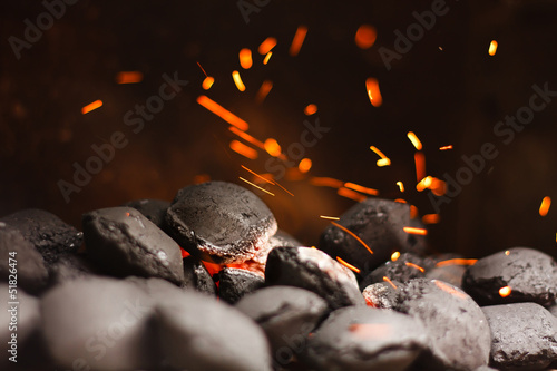 Charcoal briquettes with fire sparks.