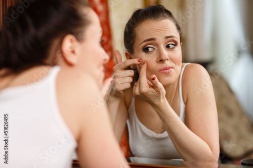 .Woman finding an acne on her cheek